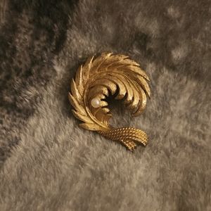 Simple gold colored pin with white stone